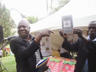 Mw. Charles Muwanga (ku kkono) ng'alaga ekitabo kya ssaayansi kye yawandiika.